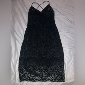Black velvet like cocktail dress with designs and a criss cross back